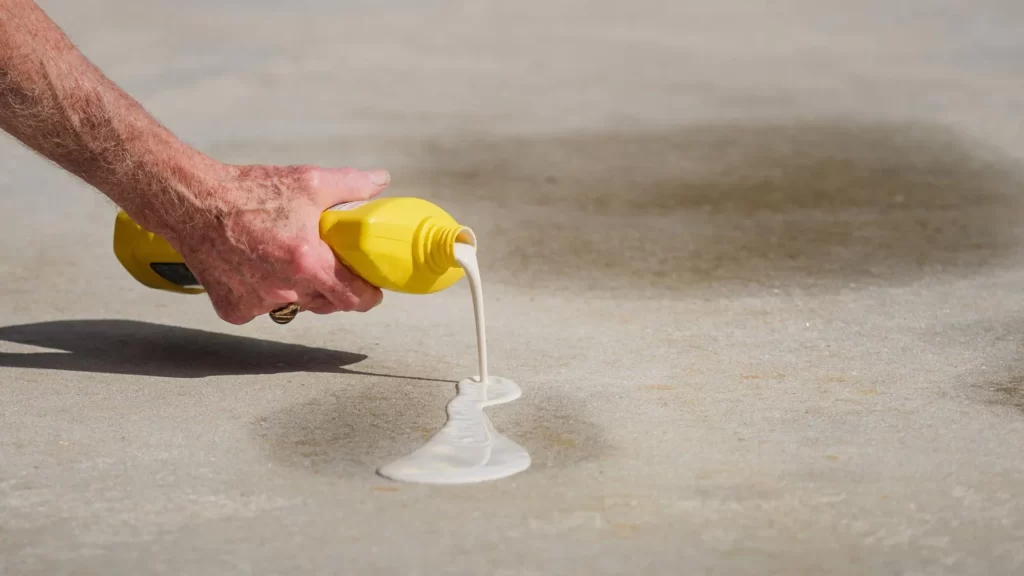 person putting stain remover in concrete floor