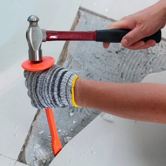 person removing floor tiles with hammer and other equipments