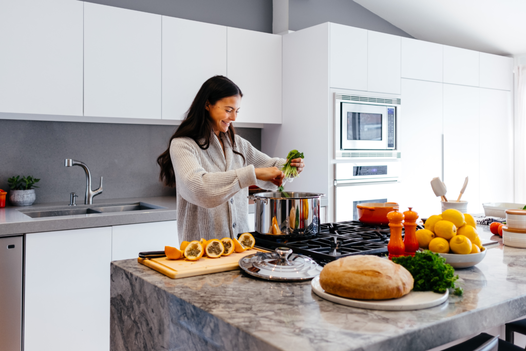 woman smiling while cooking in kitchen
