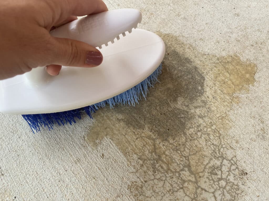 Removing rust from concrete floor with a brush