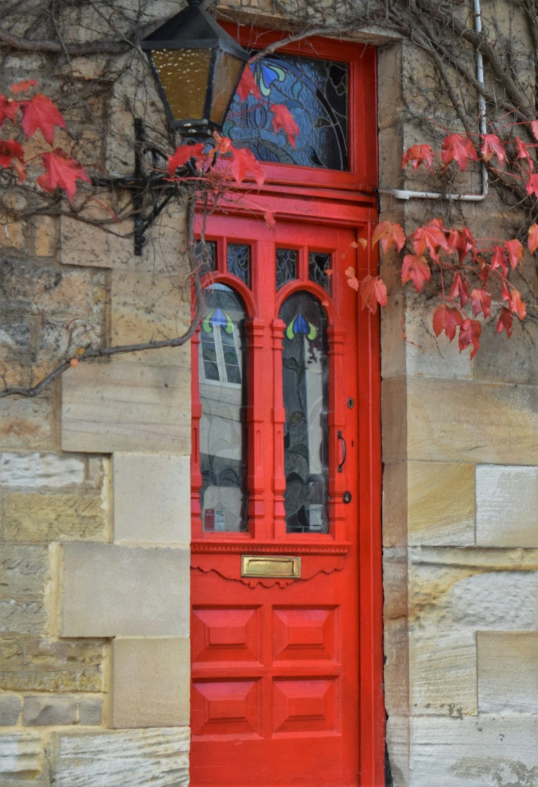 a red door with a lamp on it
