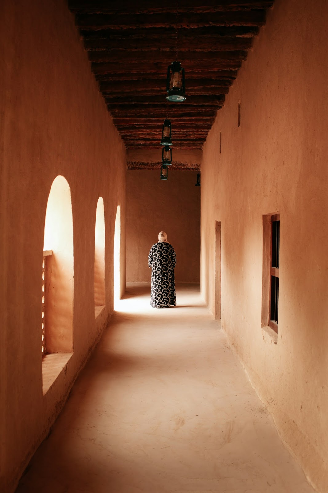 person wearing black and white dress walking on the hallway
